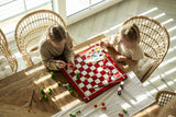 deux filles blondes peignent des pièces d'échecs rouges et vertes sur un échiquier rouge